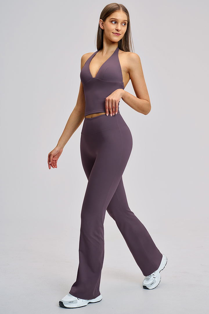 Women's athleisure set in deep purple: halter V-neck crop top with flared leggings.