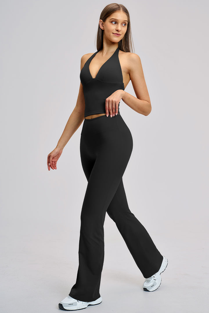 Women's athleisure set in black: halter V-neck crop top with flared leggings.