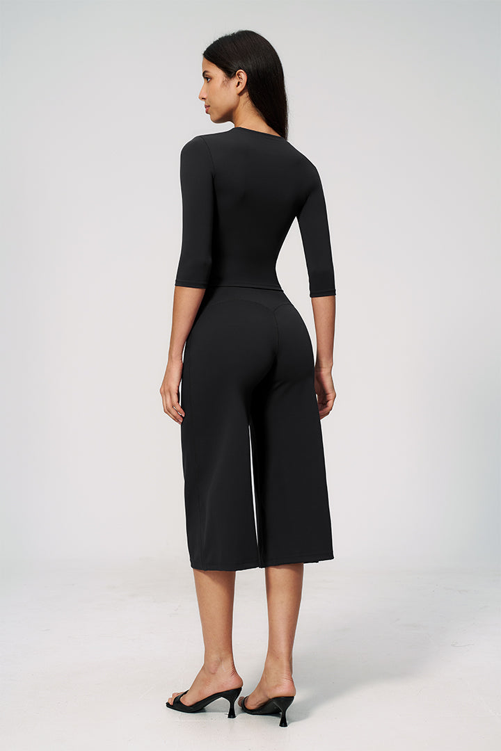 Black 2-piece outfit with back view of fitted crop top and wide-leg capri pants