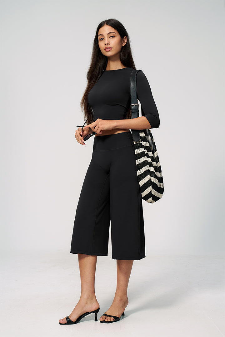 Black 2-piece crop top and wide-leg capri pants set with striped tote bag