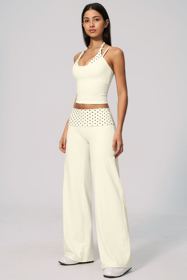 Cream halter crop top with polka-dot waist and wide-leg pants set, angled front