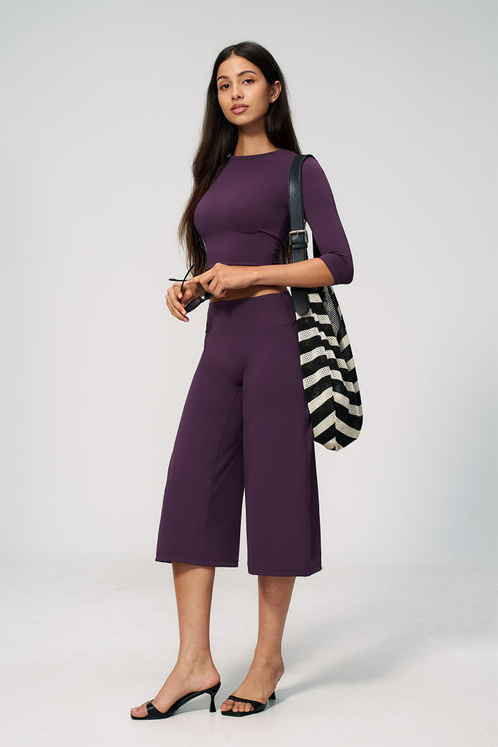 Purple two-piece set with long-sleeve cropped top and wide-leg capri pants with tote bag
