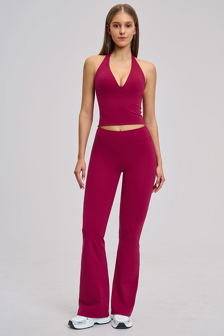 Women's athleisure set in raspberry red: halter V-neck crop top with high-waist flared leggings.